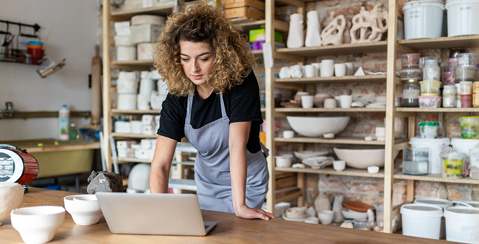 frau-mit-laptop-in-töpferei