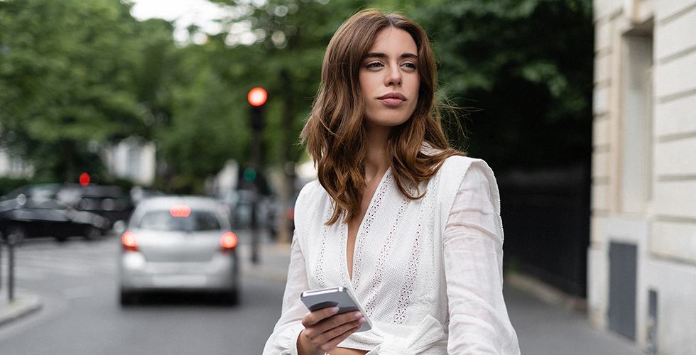 frau-mit-smartphone-an-einer-straße